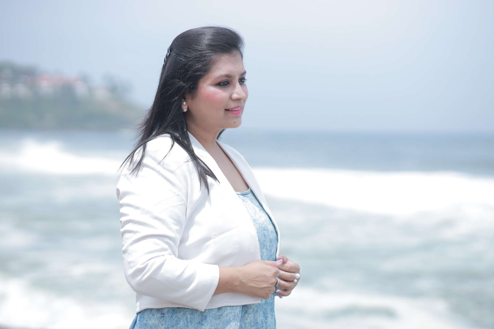 A woman looking toward the horizon by the sea